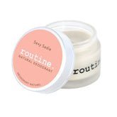 routine Sexy Sadie deodorant jar - open glass container with coral pink lid showing smooth cream texture - natural multi-use formula with ylang ylang and vanilla oils